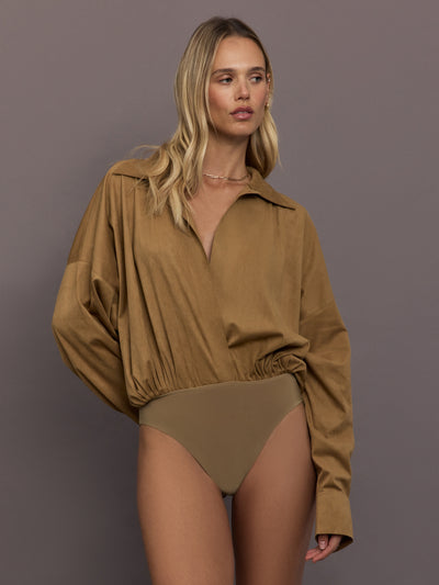 Model is wearing the Super Oversized Boyfriend Shirt Bodysuit in Camel, full body front view.
