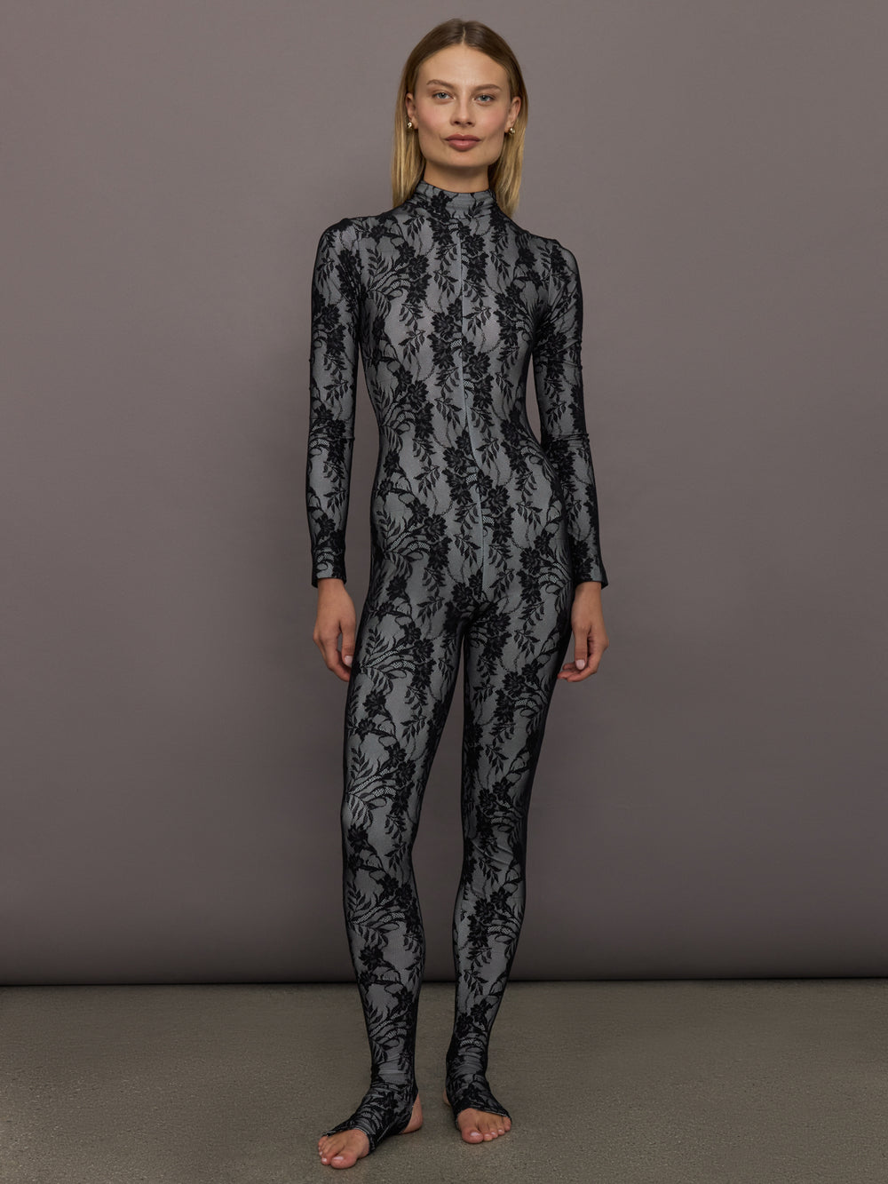 Full front view of model wearing Long Sleeve Slim Fit Turtle Catsuit with Footie Black White Lace.