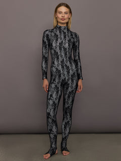 Full front view of model wearing Long Sleeve Slim Fit Turtle Catsuit with Footie Black White Lace.
