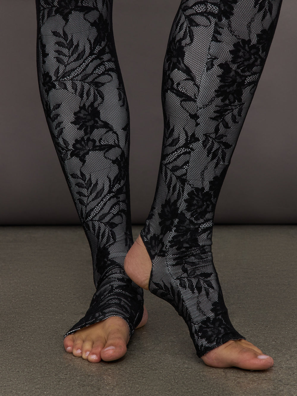 Detailed view of Long Sleeve Slim Fit Turtle Catsuit with Footie Black White Lace stirrup hem at ankles.
