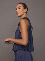Model wearing Satin Tie Shoulder Tank Top in navy styled with drawstring pants, side view.