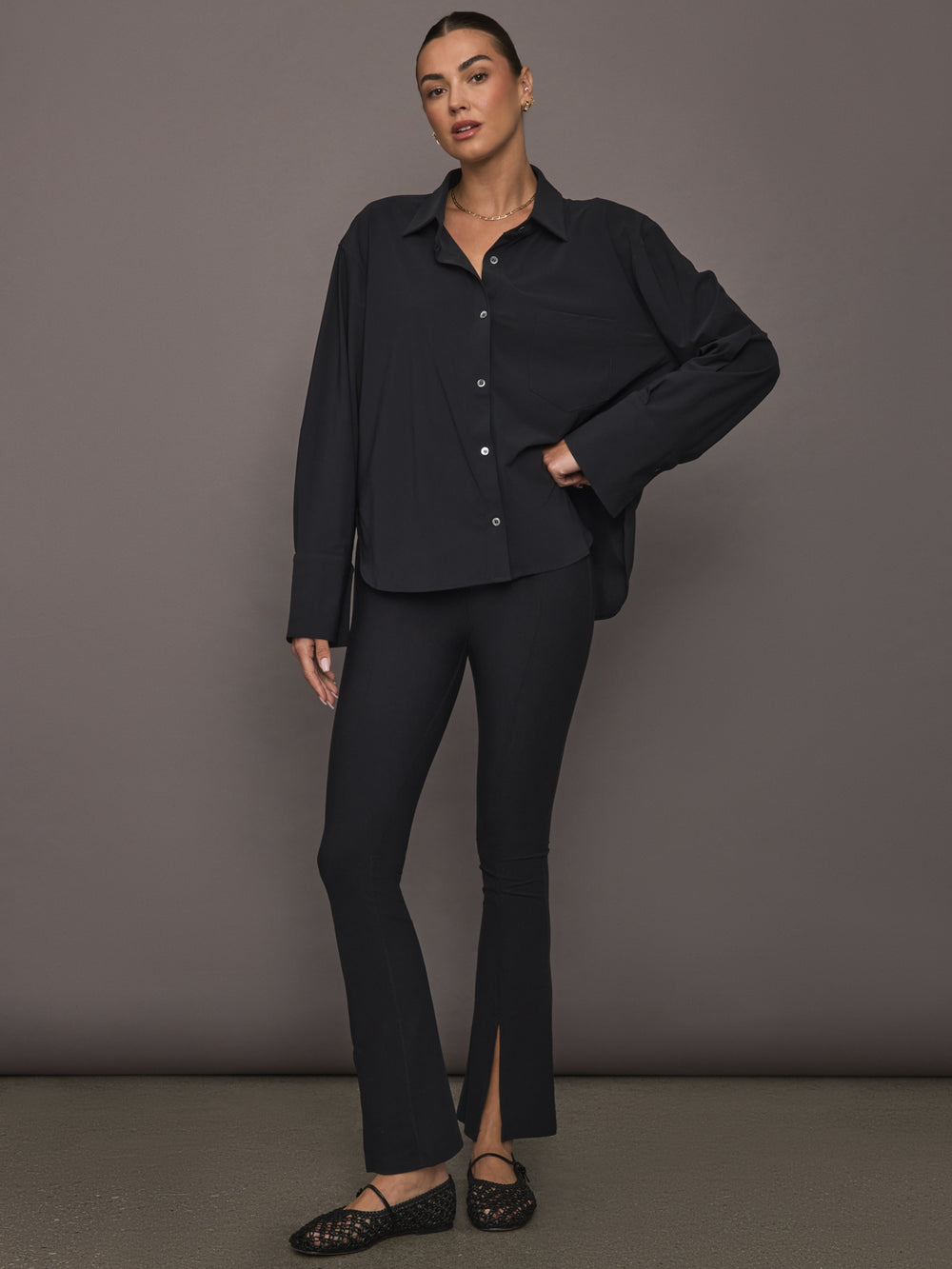 Model wearing Oversized Stretch Button-Down Shirt in black, full length view.