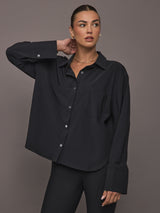 Model wearing Oversized Stretch Button-Down Shirt in black, front view.