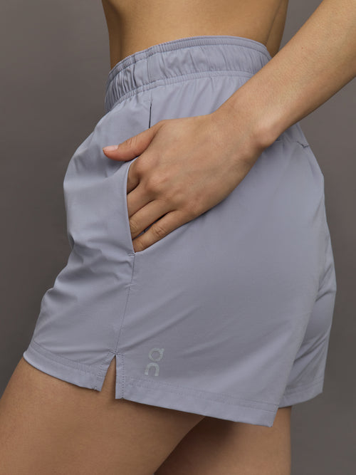 Model wears lilac-colored athletic shorts with a 3-inch inseam and an elastic waistband.