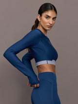 Woman wearing a blue athletic outfit on a gray background