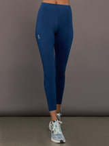 Person wearing blue leggings with a gray background