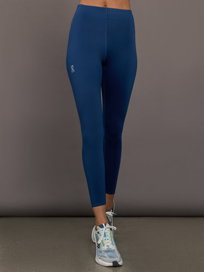 Person wearing blue leggings with a gray background