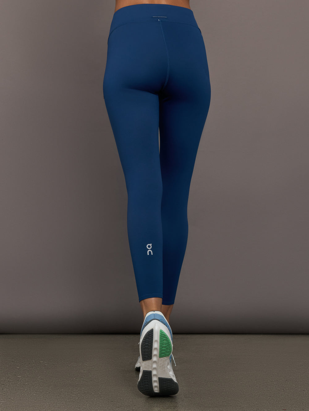 Person wearing blue leggings with a gray background
