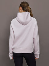 Person wearing a light purple hoodie from behind on a gray background