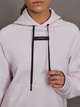 Light purple hoodie with black drawstrings on a neutral background