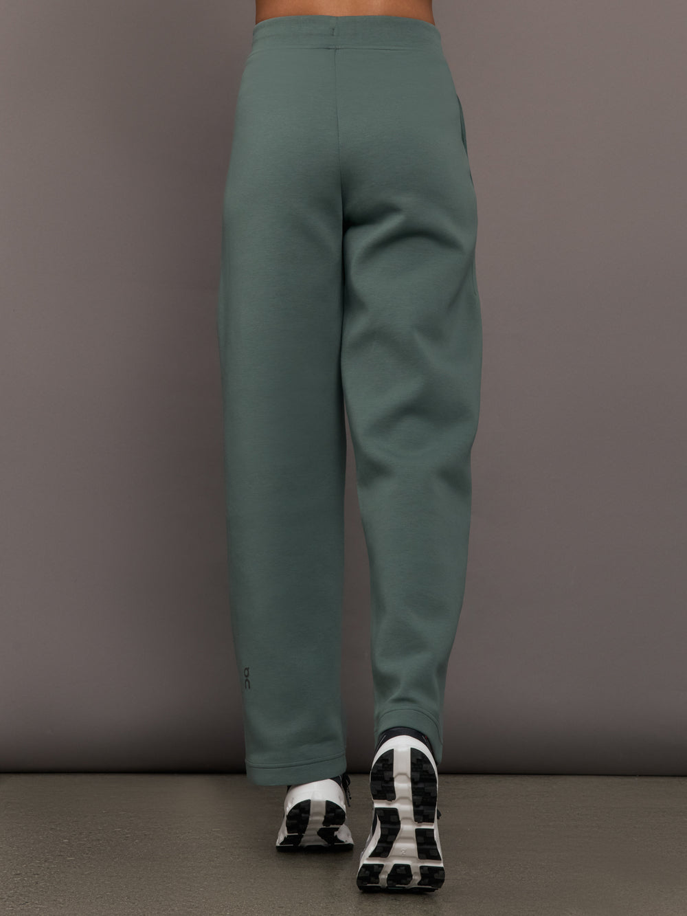 Person wearing green pants against a gray background