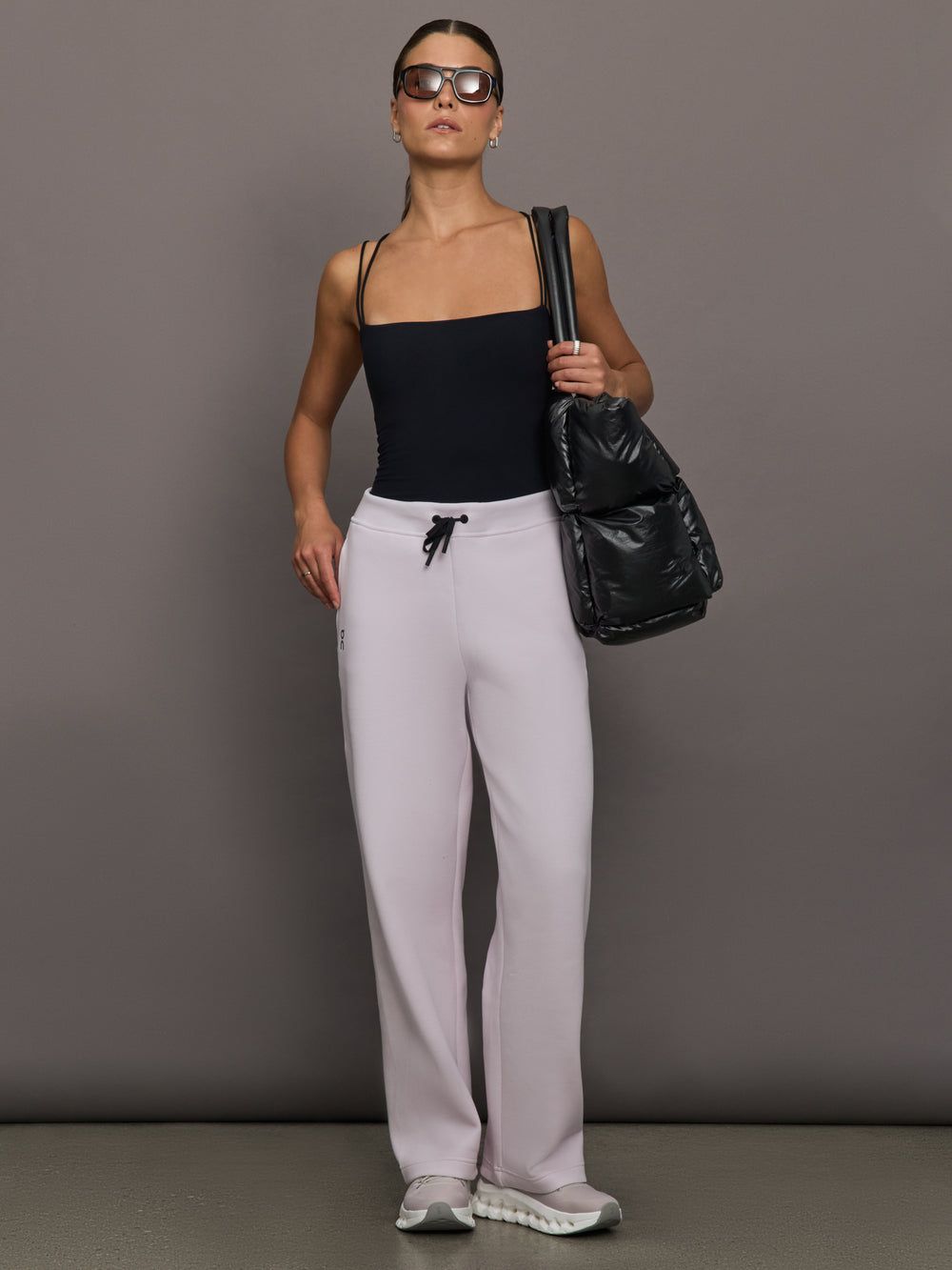 Model wears a pair of light purple sweatpants with black drawstring.