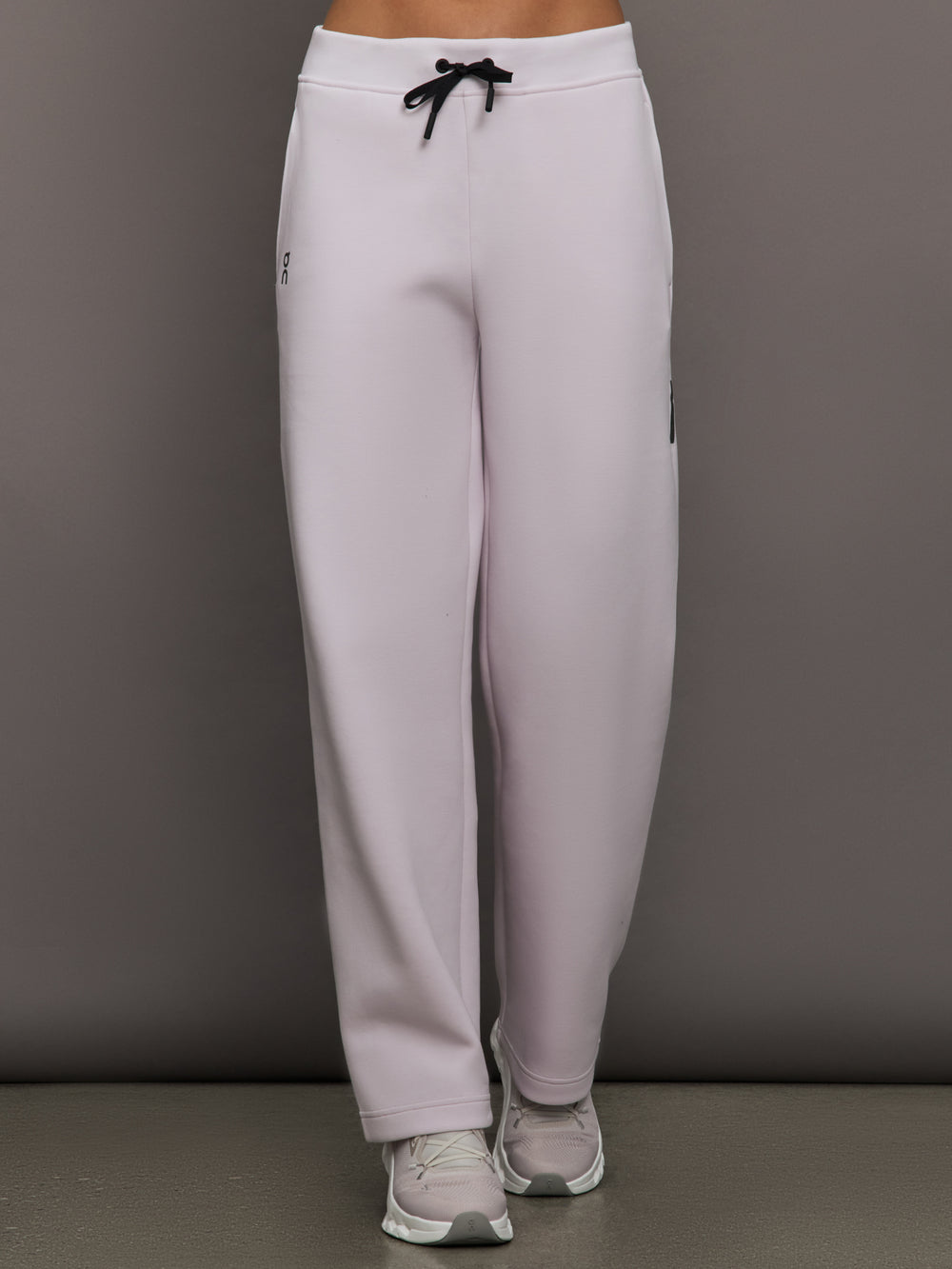 Model wears a pair of light purple sweatpants with black drawstring.