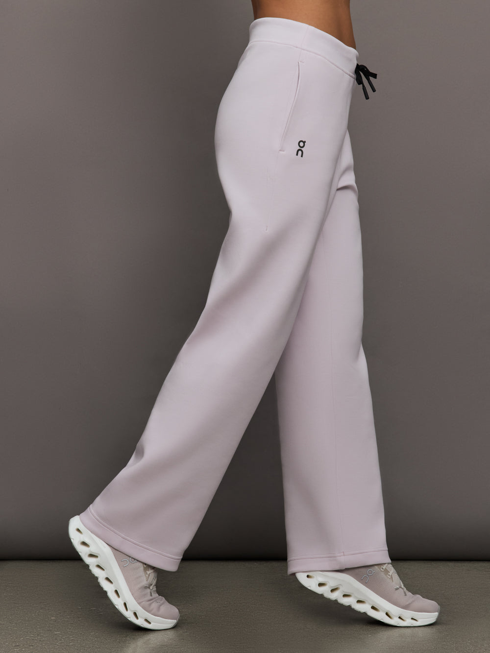 Model wears a pair of light purple sweatpants with black drawstring.