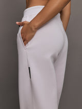 Model wears a pair of light purple sweatpants with black drawstring.