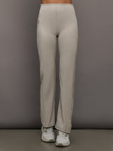 Model wears a pair of high waisted straight leg neutral pinstripe pants. 