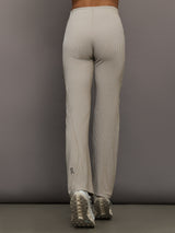 Model wears a pair of high waisted straight leg neutral pinstripe pants. 