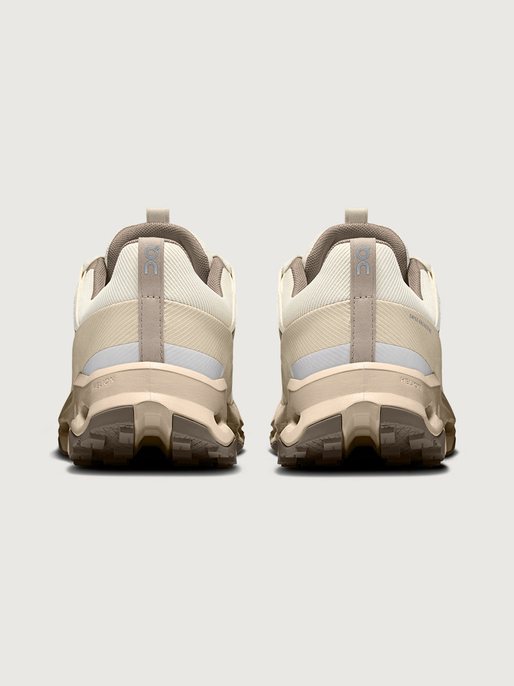 Pair of beige hiking shoes with gray accents on a light gray background