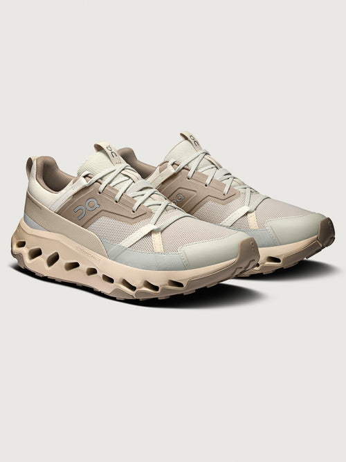 Beige hiking shoes with mesh design on a light gray background