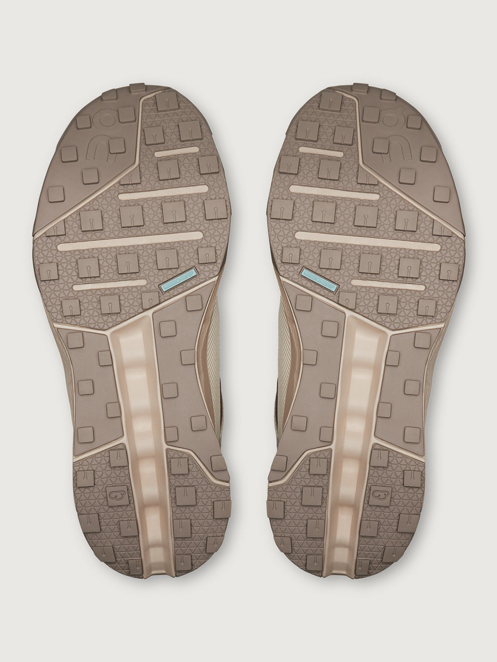 Pair of brown shoe soles on a light gray background