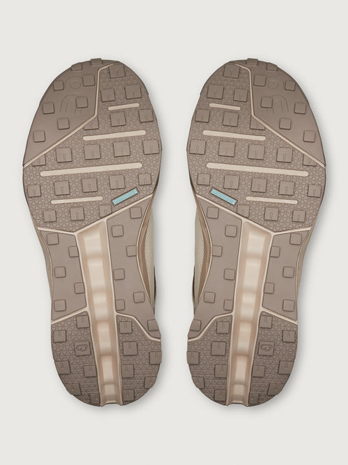 Pair of brown shoe soles on a light gray background