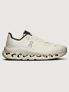 White sneakers with a unique sole design featuring circular cutouts beneath the heel area.