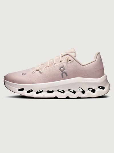 Pink running shoe with white sole on a light gray background