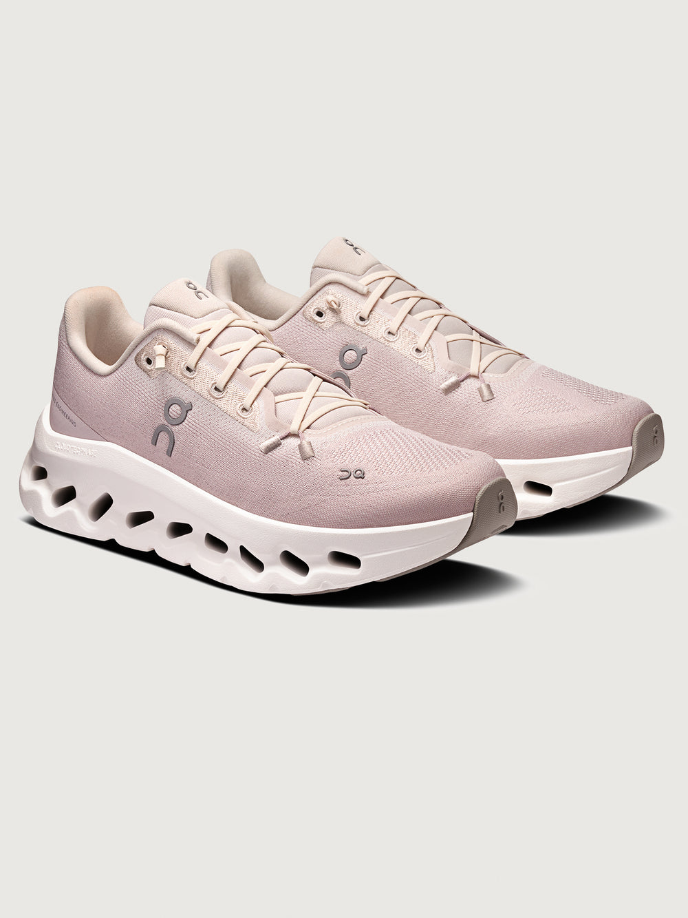Pink running shoe with white sole on a light gray background