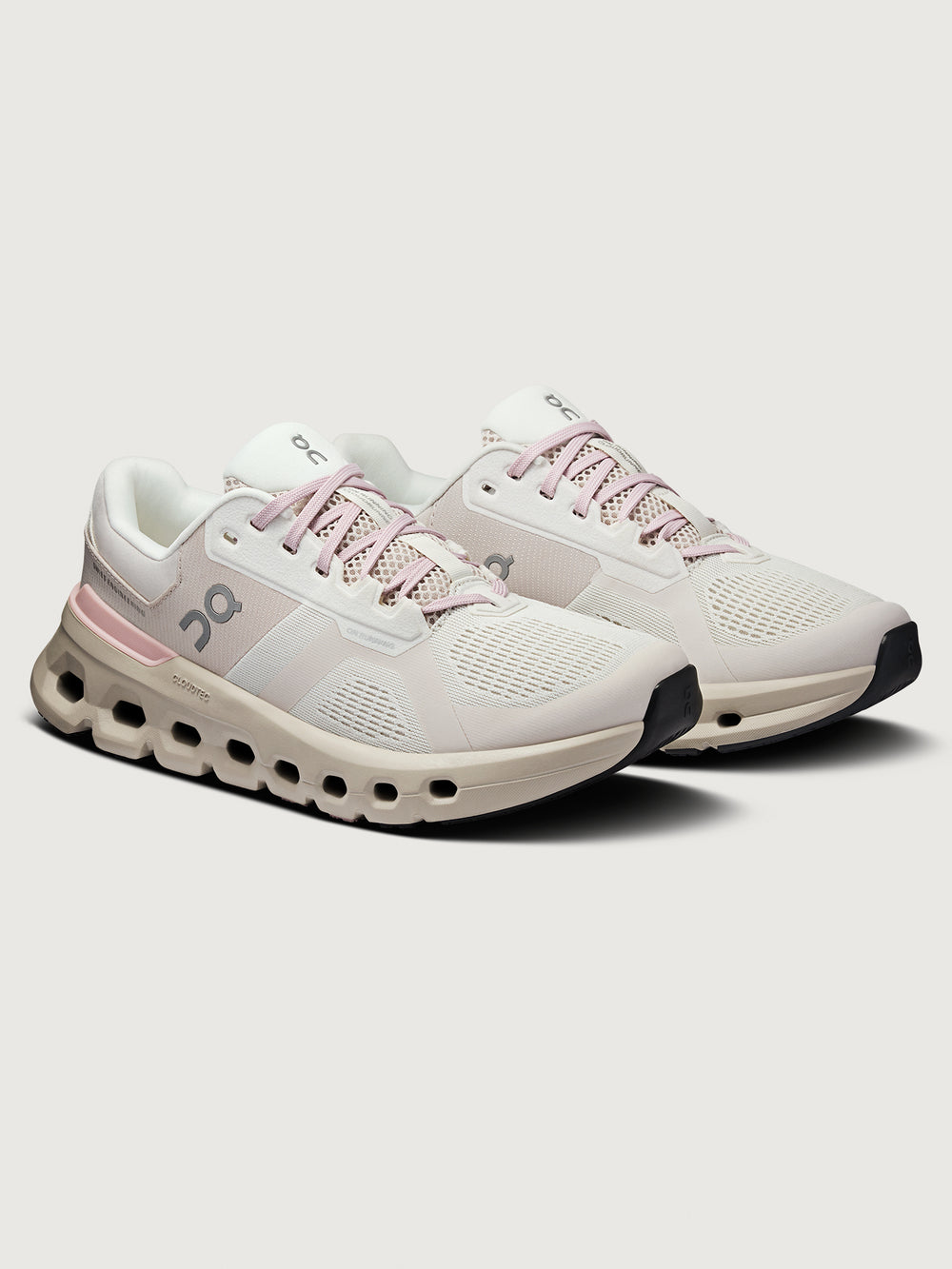 White running shoes with pink accents on a light gray background