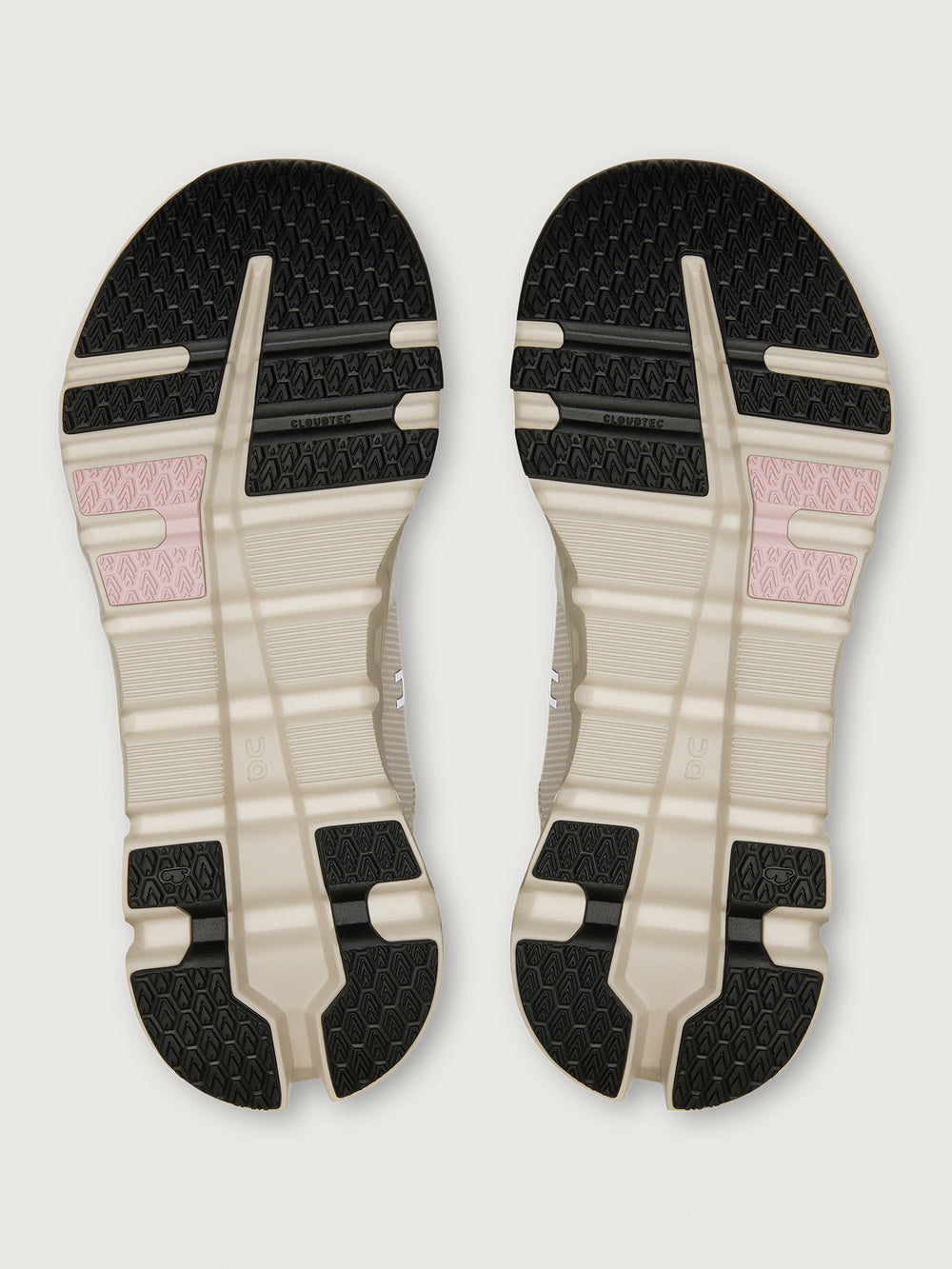 Top view of a pair of shoes with a black, white, and pink sole design on a light gray background.