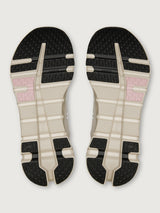 Top view of a pair of shoes with a black, white, and pink sole design on a light gray background.