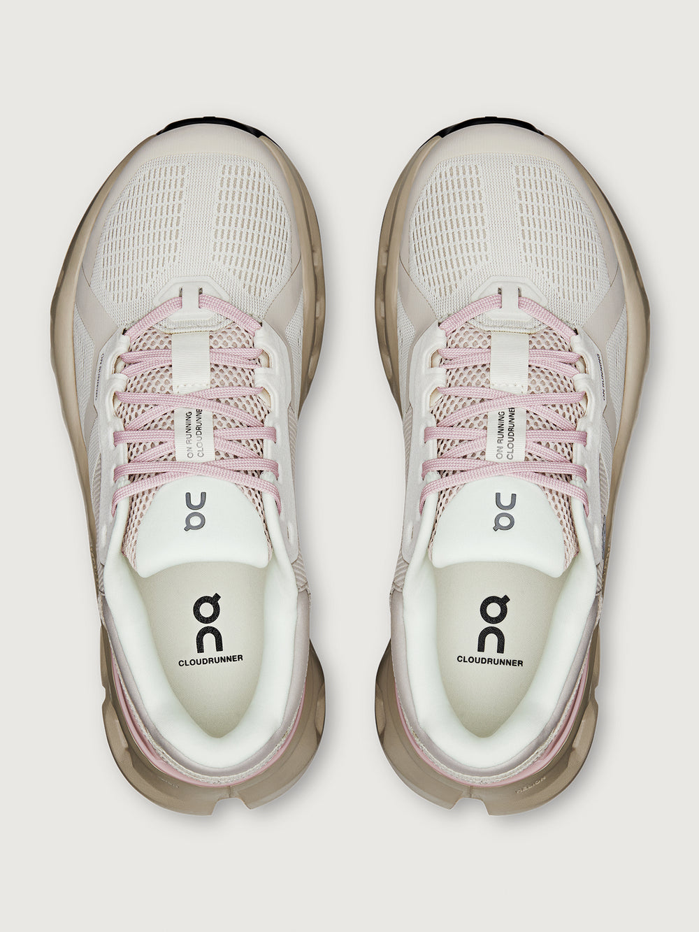 Pair of light gray and pink running shoes on a white background