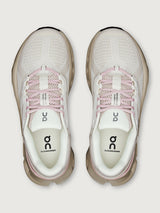 Pair of light gray and pink running shoes on a white background