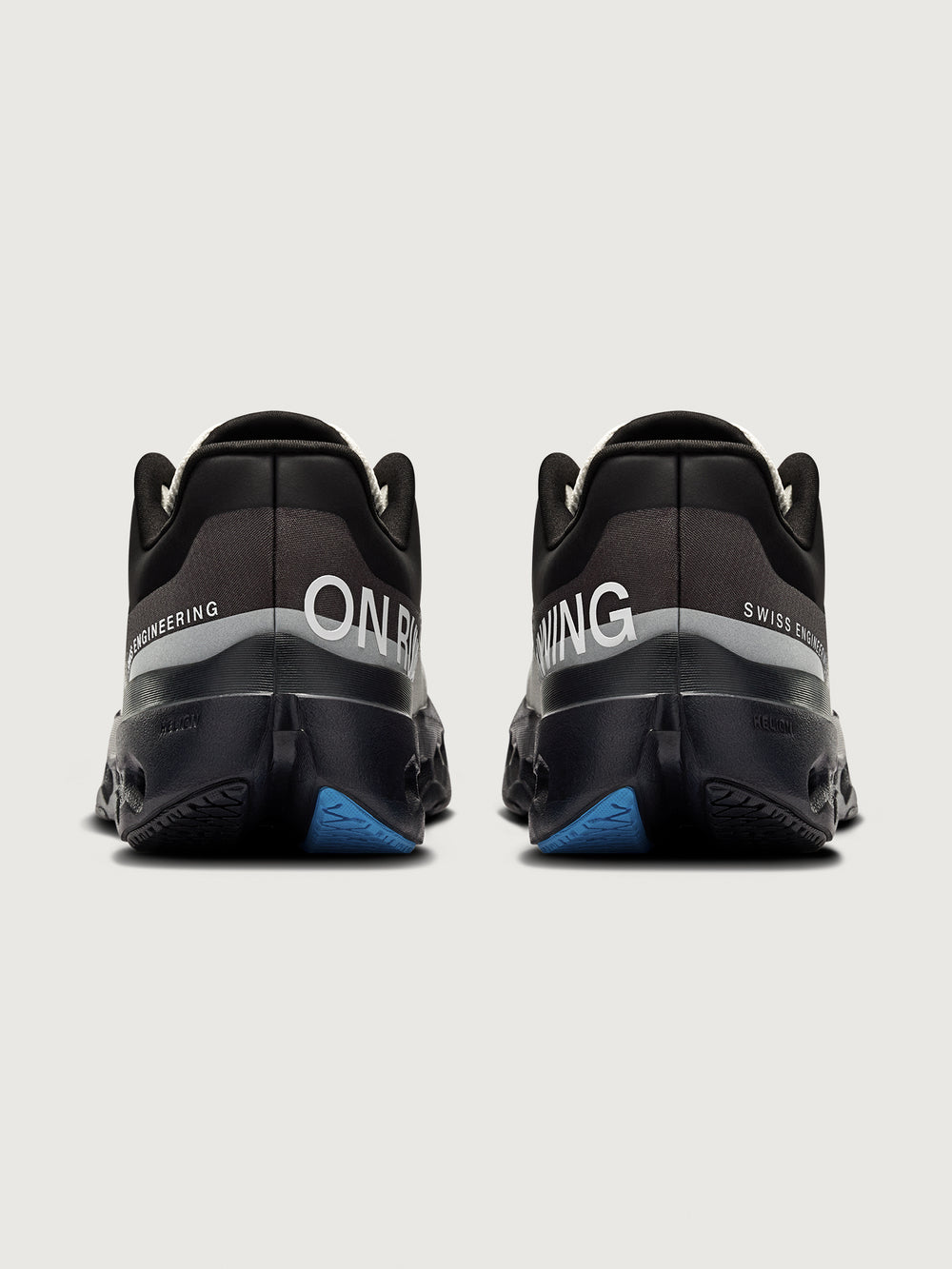 Black running shoes with blue sole on a light gray background