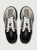 Pair of gray and black running shoes with white laces on a light gray background