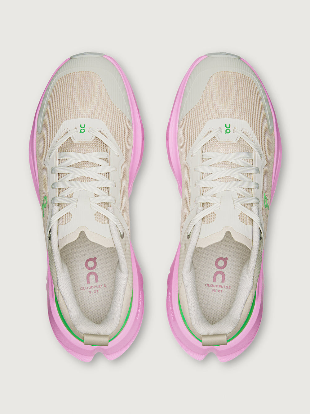 Pair of beige and pink running shoes on a white background