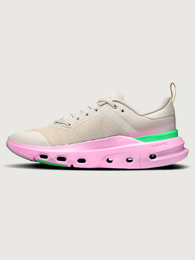 Sneaker with pink sole and green accent on a white background