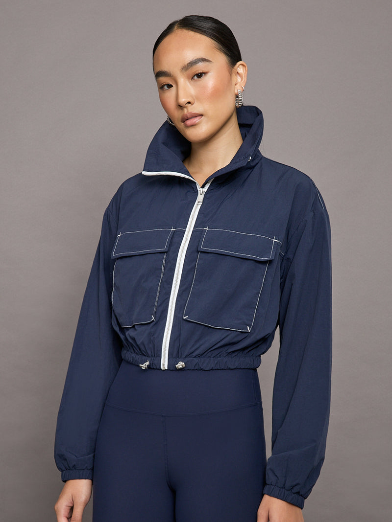 An Image of a Female Model is wearing Dark Navy Blue Zip-up Jacket