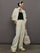 Model wears an off white track jacket with royal blue seam detailing down the sleeves. 