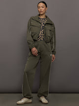 Model wears an olive colored cropped bomber with symmetrical chest pockets and white seamed detailing. 