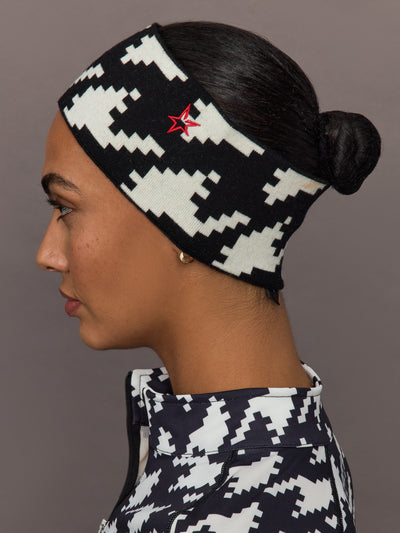 Side profile of model wearing black and white houndstooth merino wool headband with red star logo.