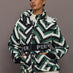 Front view of model wearing Cortina Ski Parka Waffle Print Green with belted waist.