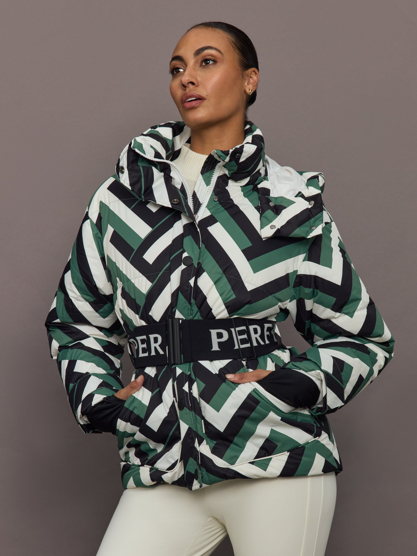 Front view of model wearing Cortina Ski Parka Waffle Print Green with belted waist.