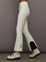 Side view of Aurora High Waist Ski Pant Snow White with red star logo at calf and black reinforced panels.
