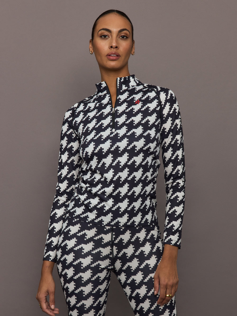 Front view of model wearing 1/4 Zip Base Layer Top in black and white houndstooth print.