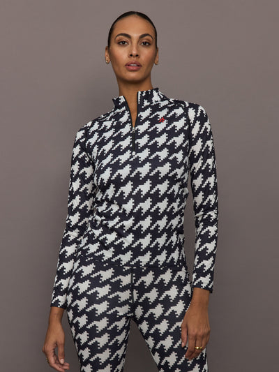 Front view of model wearing 1/4 Zip Base Layer Top in black and white houndstooth print.