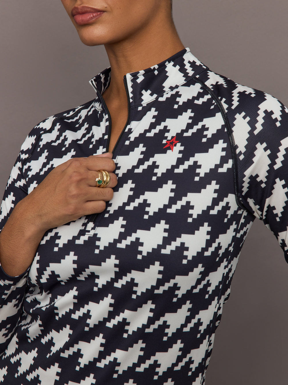 Close up of 1/4 Zip Base Layer Top in black and white houndstooth print showing zipper detail and Perfect Moment logo.