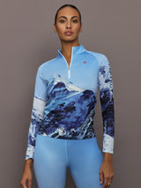 Front view of model wearing 1/4 Zip Base Layer Top in Ski Lift Blue with mountain graphic print.