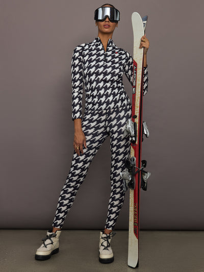 Full body view of model styled in Printed Base Layer Leggings black and white houndstooth with matching quarter zip top and ski gear.