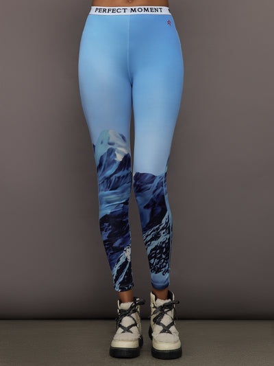 Front view of model wearing Printed Base Layer Leggings in Ski Lift Blue with mountain graphic design.